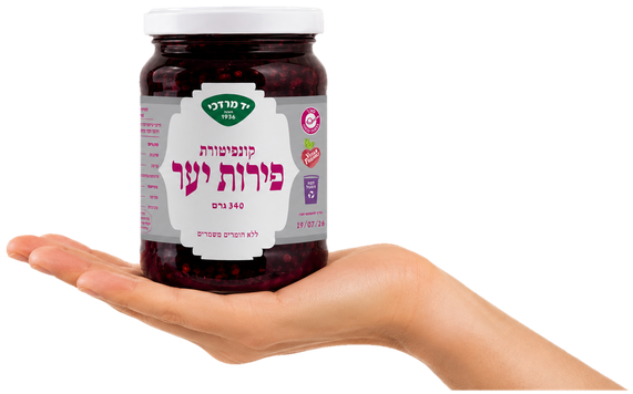 A hand holding the forest fruit jam jar