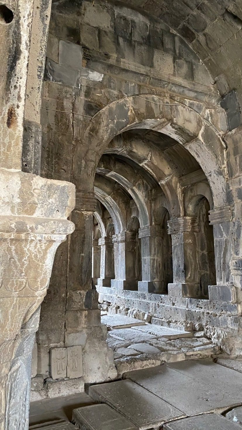 Repeating stone arches down a corridor