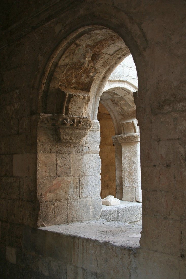 Sunlit stone corridor with vaulted arches