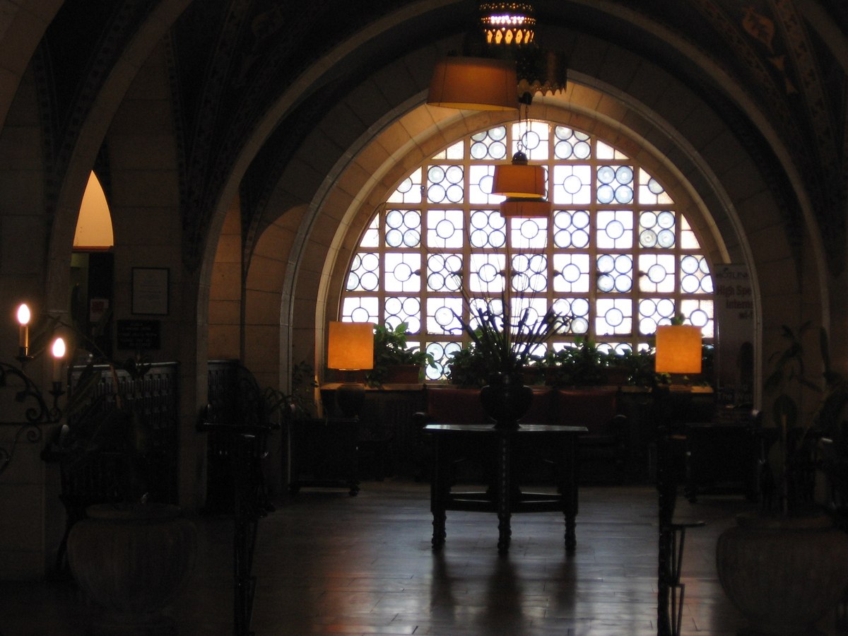 Interior arcade with arches and a large leaded window